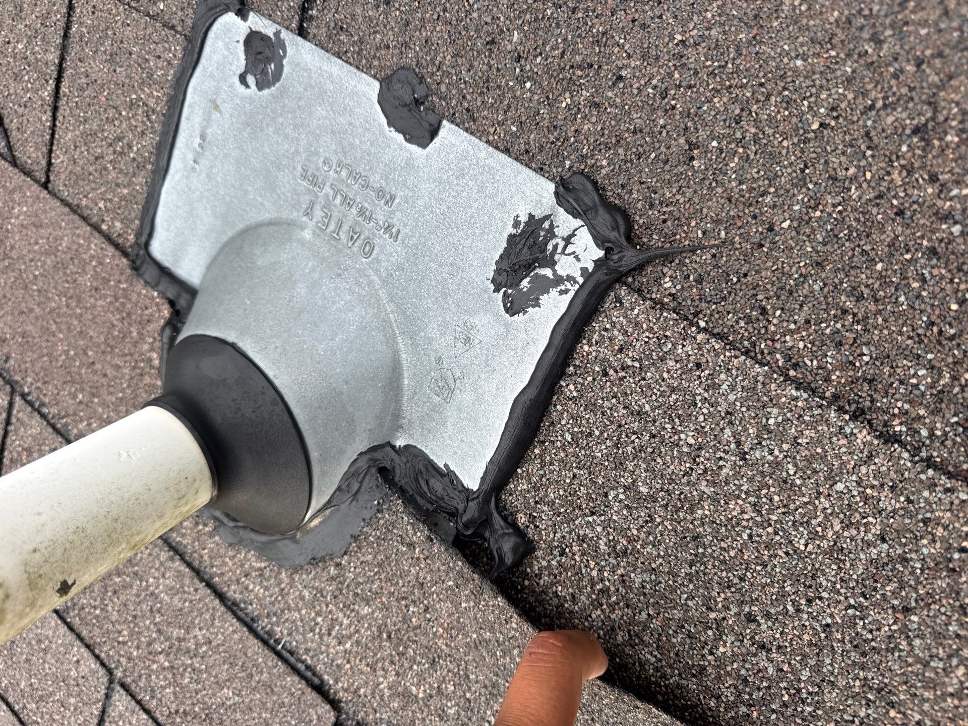 Pipe-jack flange and rubber collar photographed during a roof inspection.