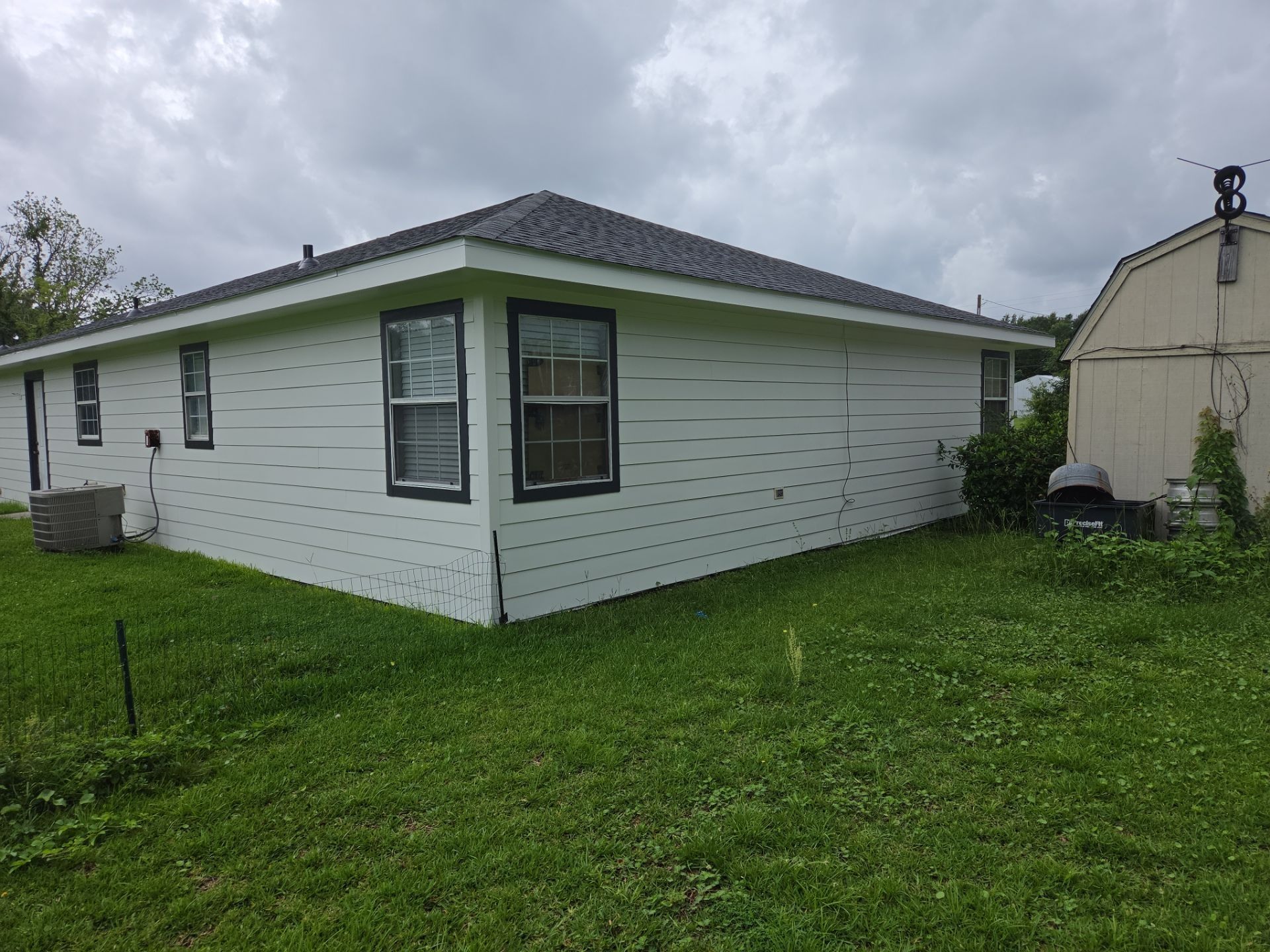 Home exterior with fresh light lap siding and black window trim