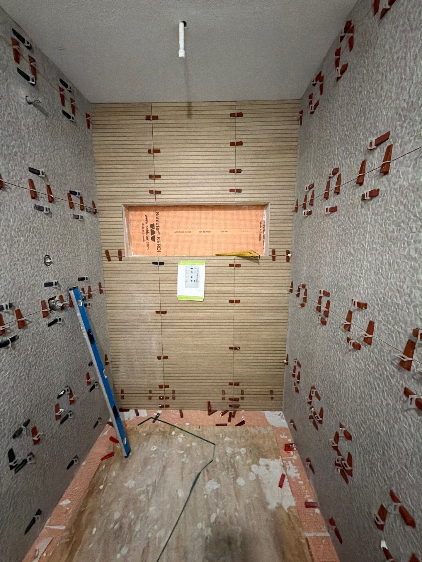 Walk-in shower mid tile install with large-format tile, an accent wall, and a built-in niche